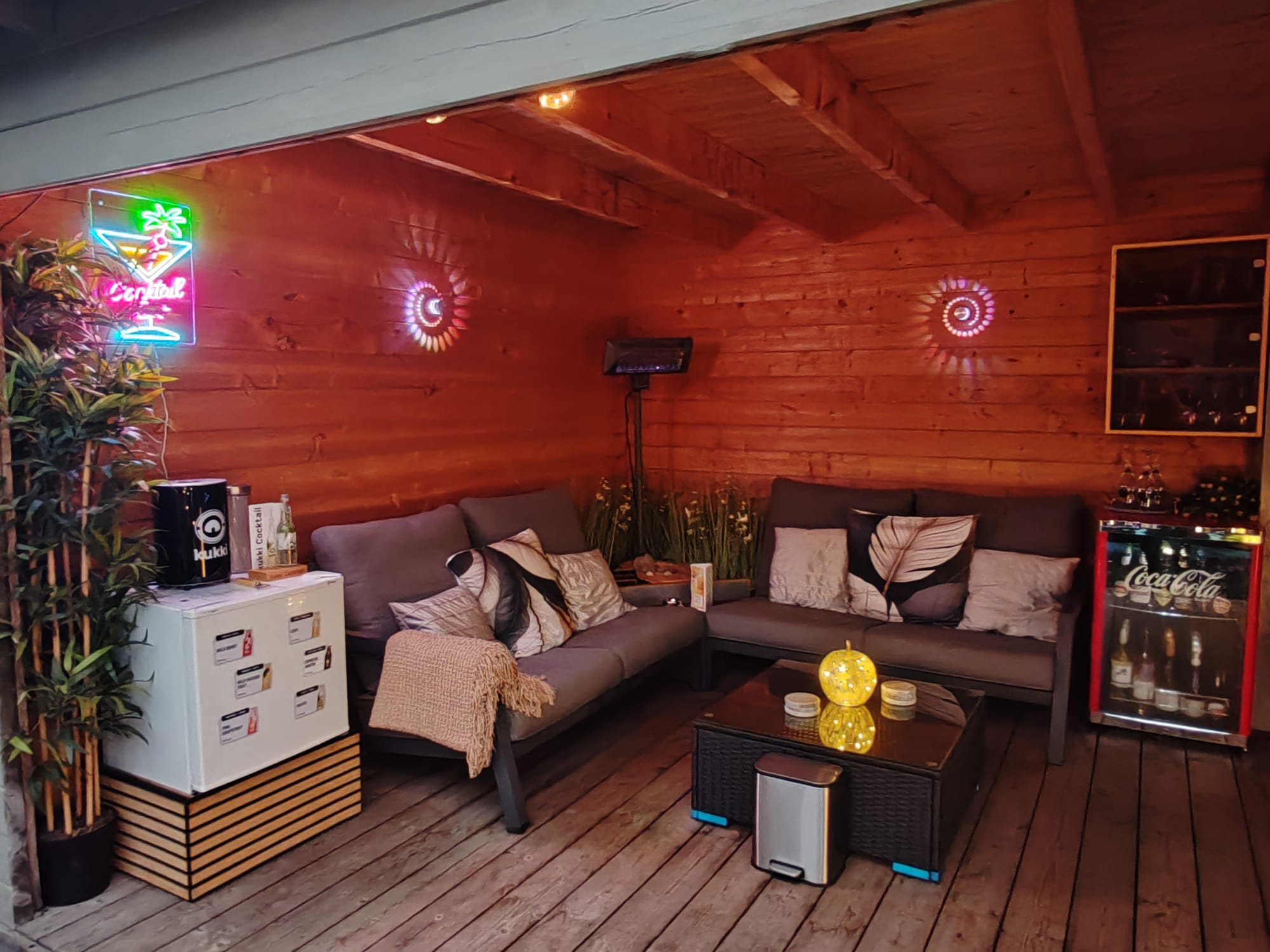 Overdekte loungehoek bij avond met sfeerverlichting